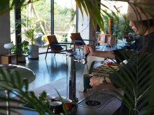 a woman sitting at a table with a coffee machine at 緩慢大鵬灣 in Donggang