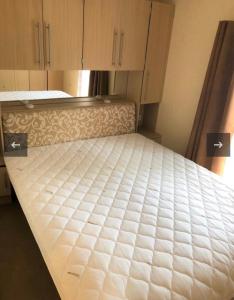 een bed in een kamer met kasten en een matras bij Vakantiehuis recreatiepark rhederlaagse meren lathum in Lathum