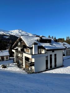 una casa con nieve encima de ella en la nieve en Sundroina holiday flat for two people Lenzerheide centre, en Lenzerheide