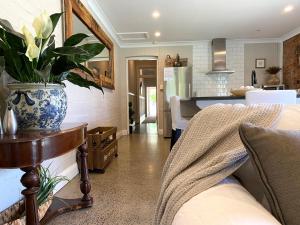 a kitchen and living room with a vase on a table at The Edward Townhouse 151 - Tastefully Styled in Orange