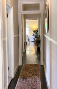 a hallway of a home with a rug at The Edward Townhouse 151 - Tastefully Styled in Orange
