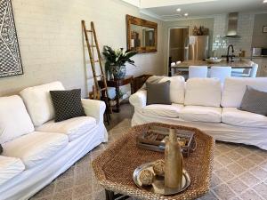 a living room with two white couches and a table at The Edward Townhouse 151 - Tastefully Styled in Orange