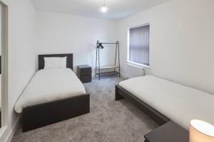 a bedroom with two beds and a window at Zetland House Apartment 1 Loftus in Loftus +1 photo