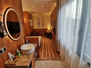 ein Badezimmer mit einem Waschbecken und einem großen Spiegel in der Unterkunft 枕窗听雨客栈 in Suzhou
