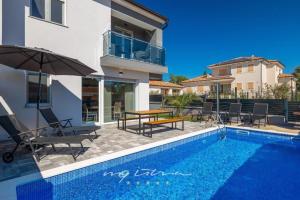 eine Villa mit einem Pool und einem Haus in der Unterkunft Villa Pearl of Istria in Rovinjsko Selo