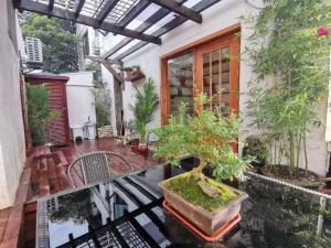 eine Terrasse mit Topfpflanzen und einem Tisch in der Unterkunft 枕窗听雨客栈 in Suzhou