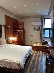 Un dormitorio con una gran cama blanca y una ventana en 枕窗听雨客栈, en Suzhou