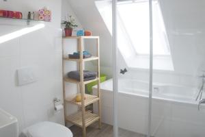 a bathroom with a wooden shelf next to a bath tub at Apartment11 Thüringer in Cologne