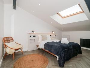 um quarto com uma cama, uma cadeira e uma clarabóia em Tilia Barn em Wincanton