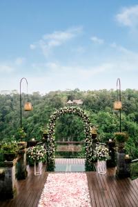 an arch with flowers on it on a deck at Pramana Watu Kurung in Ubud