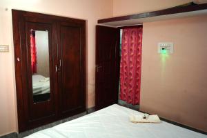 Schlafzimmer mit einem Bett, einem Spiegel und einer Tür in der Unterkunft pondy Vibes 2bhk home Stay in Puducherry