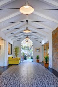 een lege lobby met een gele bank en een plafond bij Protea Hotel by Marriott Mossel Bay in Mosselbaai