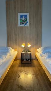 2 camas en una habitación con 2 lámparas en una mesa en B56, en Białystok