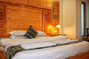 eine Reihe von Kissen auf einem Bett in einem Zimmer in der Unterkunft Hotel Zion Leh in Leh