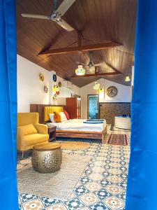 een slaapkamer met een bed en een bank bij New Common Home in Agonda