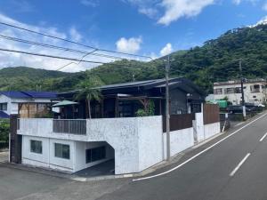 um edifício branco na berma de uma estrada em Guest House Naze - Vacation STAY 14001 em Amami
