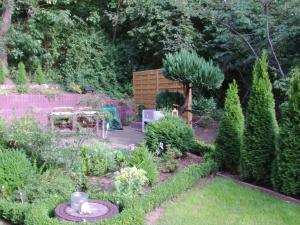 un jardín con una mesa y algunos arbustos y árboles en Halmis FeWo en Derenburg