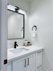 La salle de bains est pourvue d'un lavabo blanc et d'un miroir. dans l'établissement Trendy Trenholm, à Elk Grove