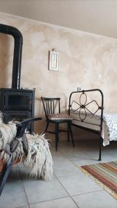 Cette chambre dispose d'une cheminée, d'un banc et d'une chaise. dans l'établissement Bilkarskata Kashta, à Gorsko Slivovo