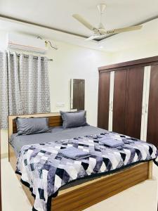 - une chambre avec un lit et une couverture en damier dans l'établissement Abode Stayz Service Apartments, à Hyderabad