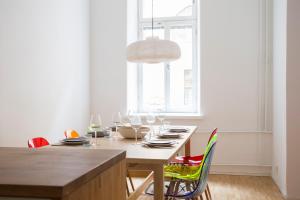 a dining room with a table with chairs and a light fixture at 2ndhomes Bright & Spacious 97m2 2BR Apartment w/Sauna in Katajanokka in Helsinki