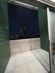 a bathroom with a view of the city at night at Pinheiros Duplex no pool in São Paulo