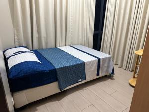 ein Schlafzimmer mit einem Bett mit einer blauen und weißen Decke in der Unterkunft Family Home in The Florence McKinley Hill Taguig in Manila