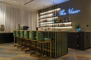 a bar with green chairs at a restaurant at Almond Hotel - Adults only in Neve Ilan +93 photos
