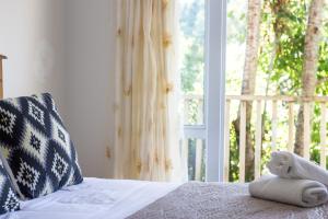 a stuffed animal sitting on a bed in front of a window at Aston Norwood Chalets in Upper Hutt