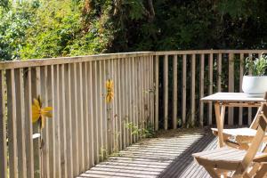 a wooden fence with a table and a flower on it at Aston Norwood Chalets in Upper Hutt