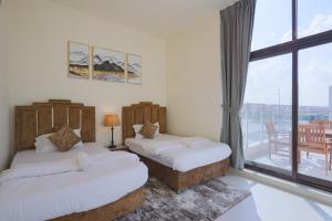 two beds in a room with a balcony at Fabulous 4br villa with Balcony in Dubai