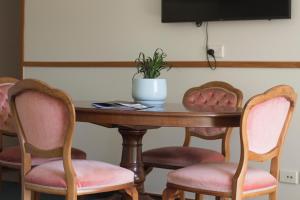 a table with chairs and a potted plant on it at Aston Norwood Chalets in Upper Hutt