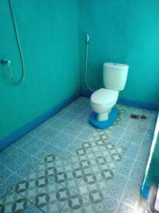 baño con aseo en una pared verde en MBE BALENG KU, en Mangsit