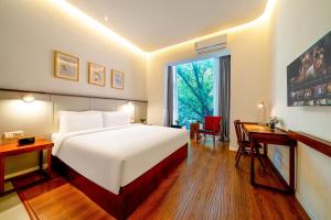 1 dormitorio con cama, escritorio y ventana en Wuyu Hotel - Chongqing Shapingba Three Gorges Plaza en Chongqing