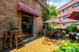 重慶市にあるWuyu Hotel Independent villa- Immersive Chinese Cultural Experienceのレンガ造りの建物で、パティオ(テーブル、椅子付)