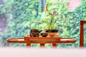a table with two pots and a plant on it at Wuyu Hotel - Chongqing Shapingba Three Gorges Plaza in Chongqing