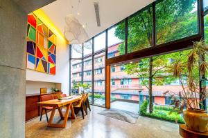 een eetkamer met een tafel en grote ramen bij Wuyu Hotel - Chongqing Shapingba Three Gorges Plaza in Chongqing