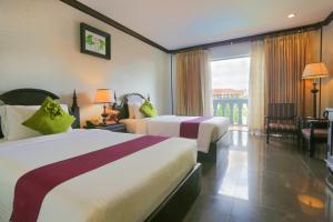 a hotel room with two beds and a balcony at Lucky Angkor Hotel & Spa in Siem Reap