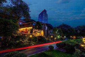 a city street at night with a tall building at Wuyu Hotel - Chongqing Shapingba Three Gorges Plaza in Chongqing