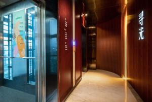 a hallway of a building with a glass door at Xunguang Hotel - Chongqing Liangjiang Happiness Plaza in Chongqing