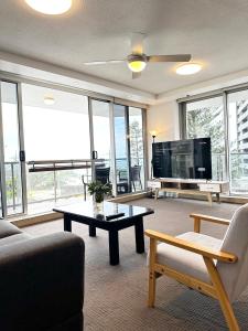 a living room with a couch and a tv at Core beachfront 2 Bedrooms Apartment by Gold Coast Premium in Gold Coast