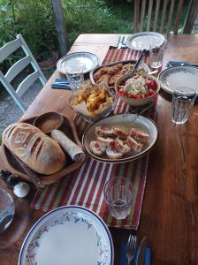 una mesa de madera con platos de comida. en Bilkarskata Kashta en Gorsko Slivovo