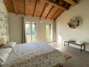 una camera con un grande letto e una grande finestra di Canovetta Country House "Camelia" - nearby Cremona 