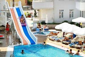 een groep mensen in een zwembad met een glijbaan bij Merve Sun Hotel & SPA in Side