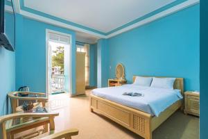 um quarto azul com uma cama e uma janela em Kim Long Hotel Đà Lạt em Da Lat