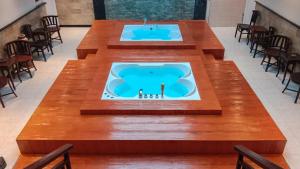 a large table in a room with a bath tub at Mahestu Hotel in Kuta