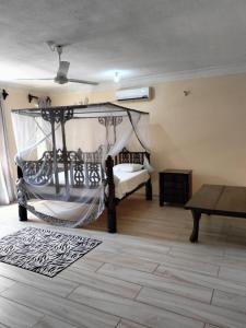 a bedroom with a bed with a hammock in it at Makao Nafuu Aprtments Malindi in Malindi