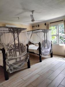 a bedroom with two beds with curtains on them at Makao Nafuu Aprtments Malindi in Malindi