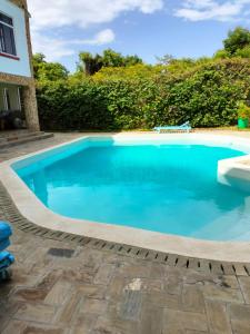 a swimming pool with blue water in a yard at Makao Nafuu Aprtments Malindi in Malindi
