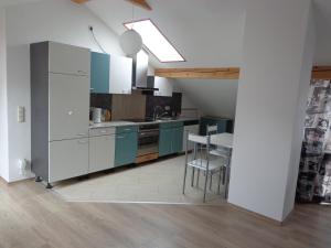 a kitchen with white and blue cabinets and a table at Ferienwohnung Bosch in Seeg